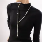 Freshwater Pearl & Gold Necklace 2 LIVKE’s irregular freshwater pearl necklace on a gold chain, styled with a beige sweater for minimalist everyday elegance.