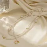 Freshwater Pearl & Gold Necklace 3 LIVKE’s irregular freshwater pearl necklace on a gold chain, styled with a beige sweater for minimalist everyday elegance.