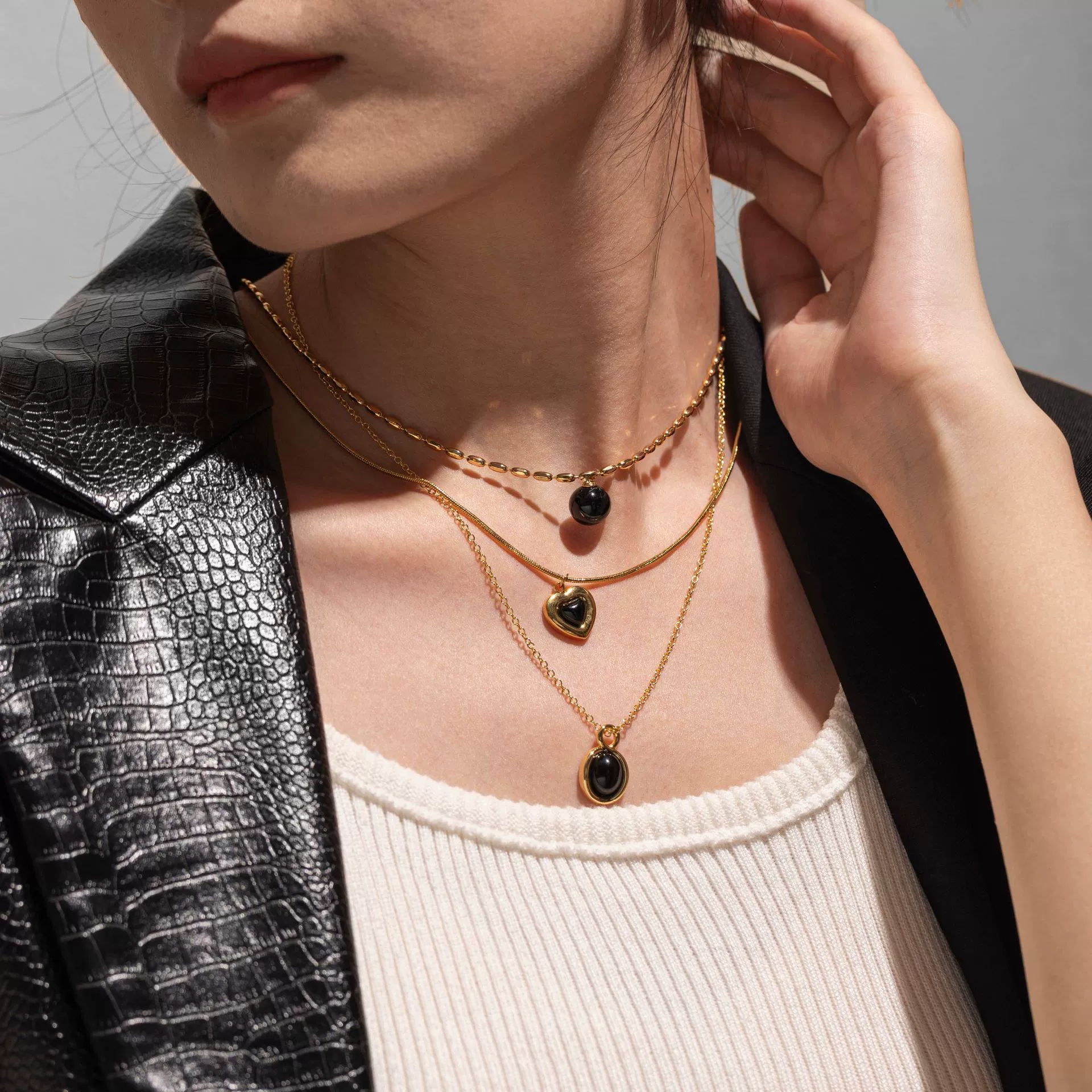 LIVKE’s gold-plated agate heart necklace styled with black silk dress for timeless minimalist elegance