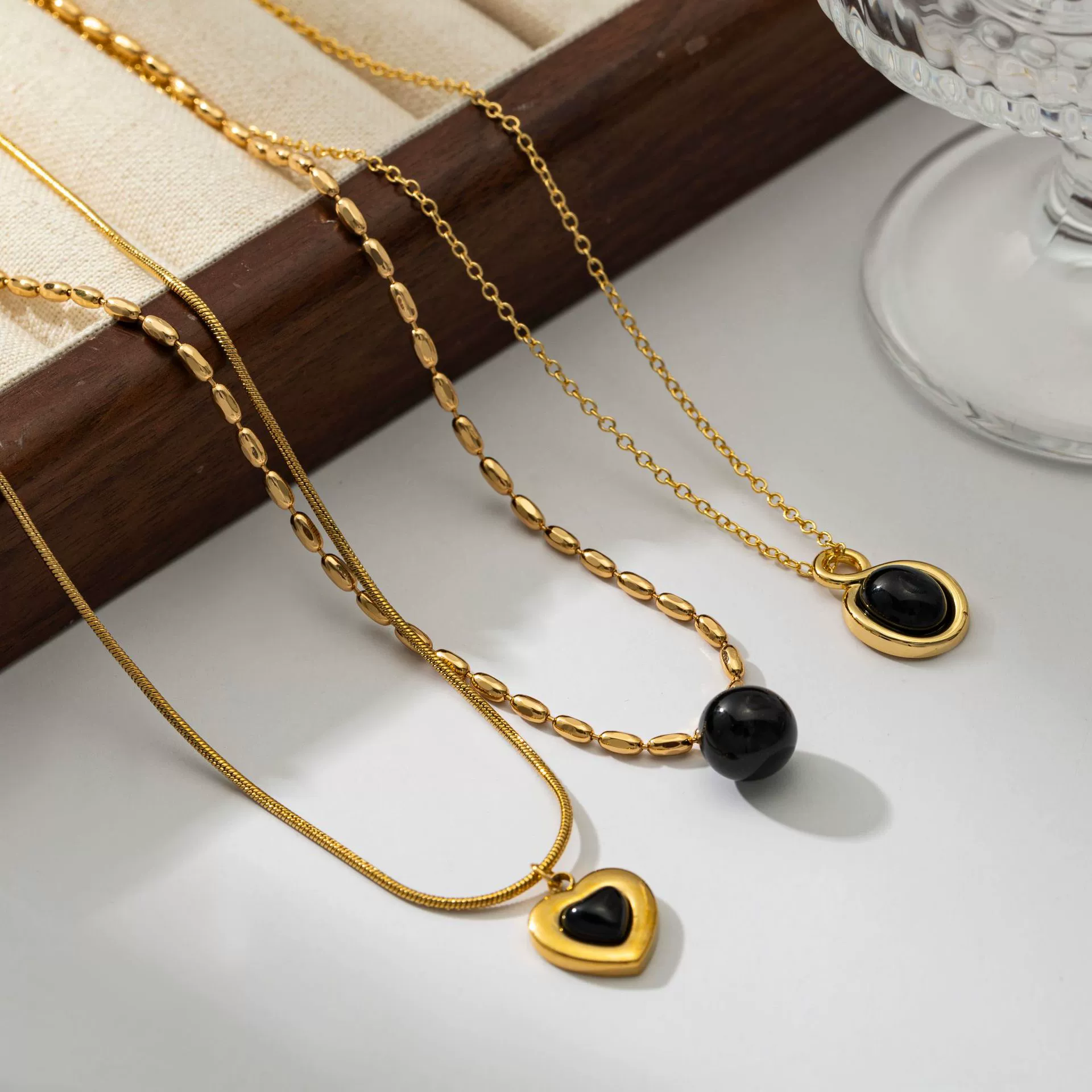 LIVKE’s gold-plated agate heart necklace styled with black silk dress for timeless minimalist elegance