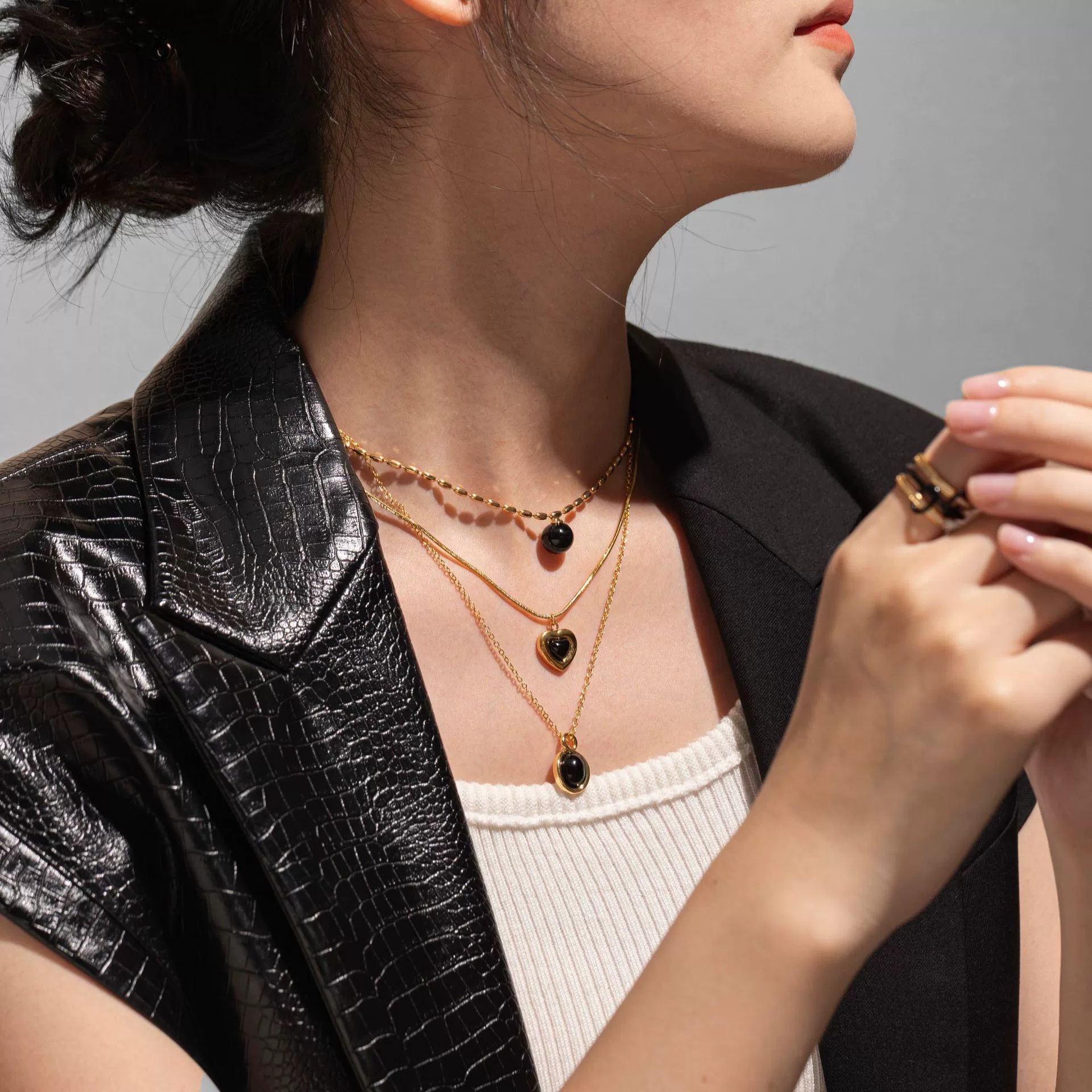 LIVKE’s gold-plated agate heart necklace styled with black silk dress for timeless minimalist elegance