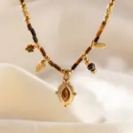 Maillard-Style Tiger Eye Necklace – 18K Gold-Plated 4 LIVKE’s oval tiger eye necklace with 18K gold-plated chain, styled with black sweater for minimalist elegance.