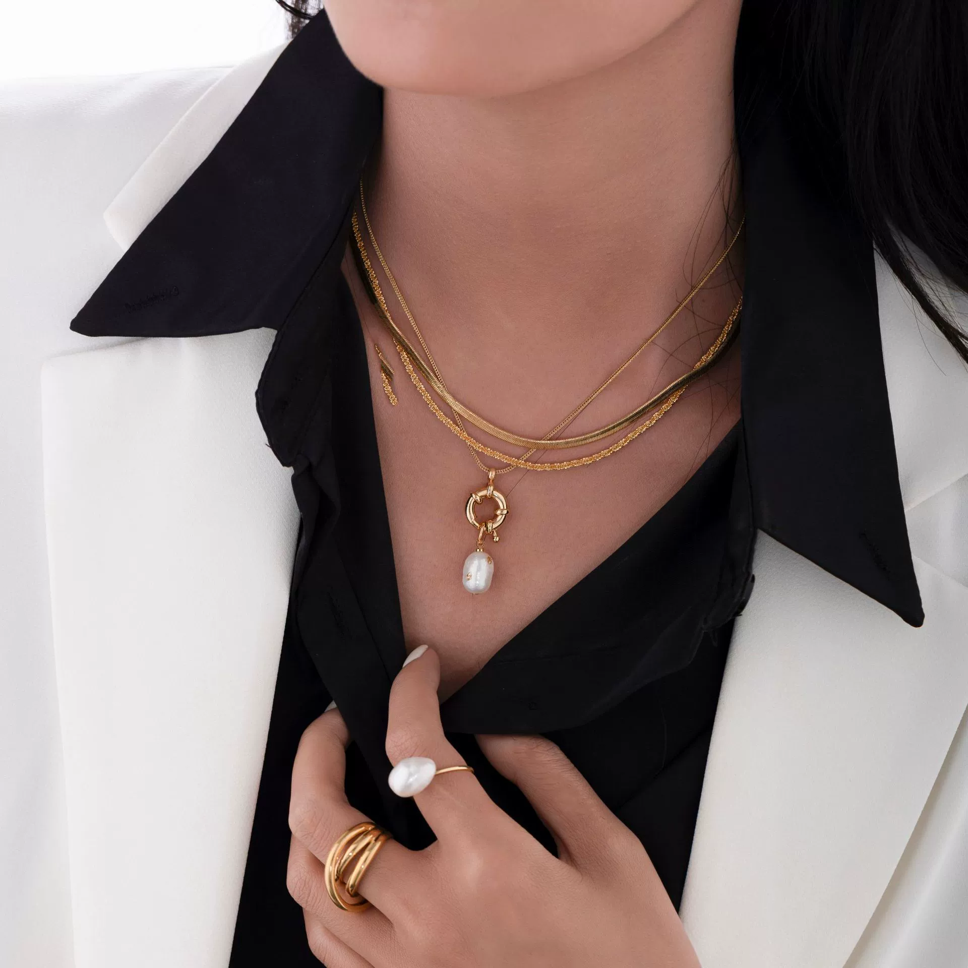 English: “Close-up of LIVKE’s 18K gold plated oval bead necklace in vintage palace style, styled elegantly on a model.”