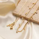 18K Gold Circular Lock Necklace 4 Close-up of LIVKE’s electroplated 18K gold brass zircon stone necklace with a round lock clasp, styled over a chic neckline.