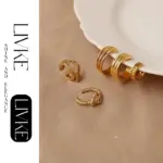 LIVKE’s gold openwork ear cuff styled on a helix, paired with minimalist hoops for edgy everyday elegance.