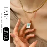Boho Shell & Turquoise Pendant Necklace 5 LIVKE’s gold snake chain necklace with shell and turquoise pendant, layered with beaded bracelets for boho summer style.