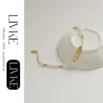French Elegance Pearl Bracelet 3 LIVKE’s French pearl bracelet with gold and zirconia accents, styled with a striped Breton top for effortless Parisian elegance.