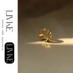 Industrial Minimalist Gear Ring 3 LIVKE’s gold gear ring on a hand with black polish, styled with a leather jacket for urban minimalist edge.