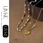 Layered 3D Heart Necklace Set 3 LIVKE’s gold layered heart necklaces styled with a black turtleneck for minimalist everyday elegance.