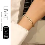 18K Gold-Plated Pearl Chain Bracelet 3 LIVKE’s gold pearl chain bracelet styled on a wrist with a linen sleeve for boho everyday elegance.