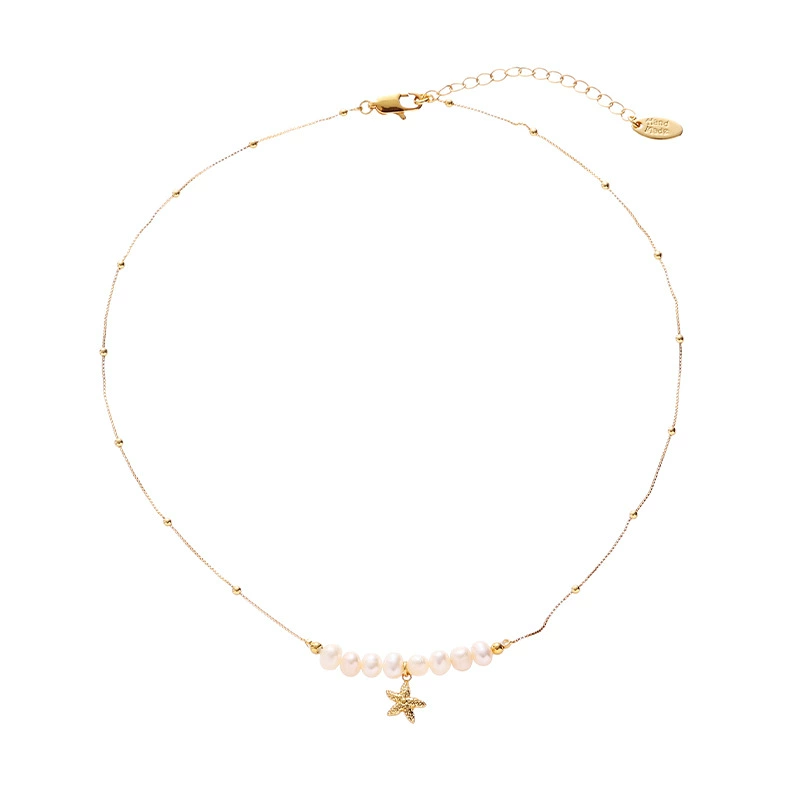 LIVKE’s layered pearl and shell necklaces styled with a white sundress and straw bag for beach-to-bar elegance.