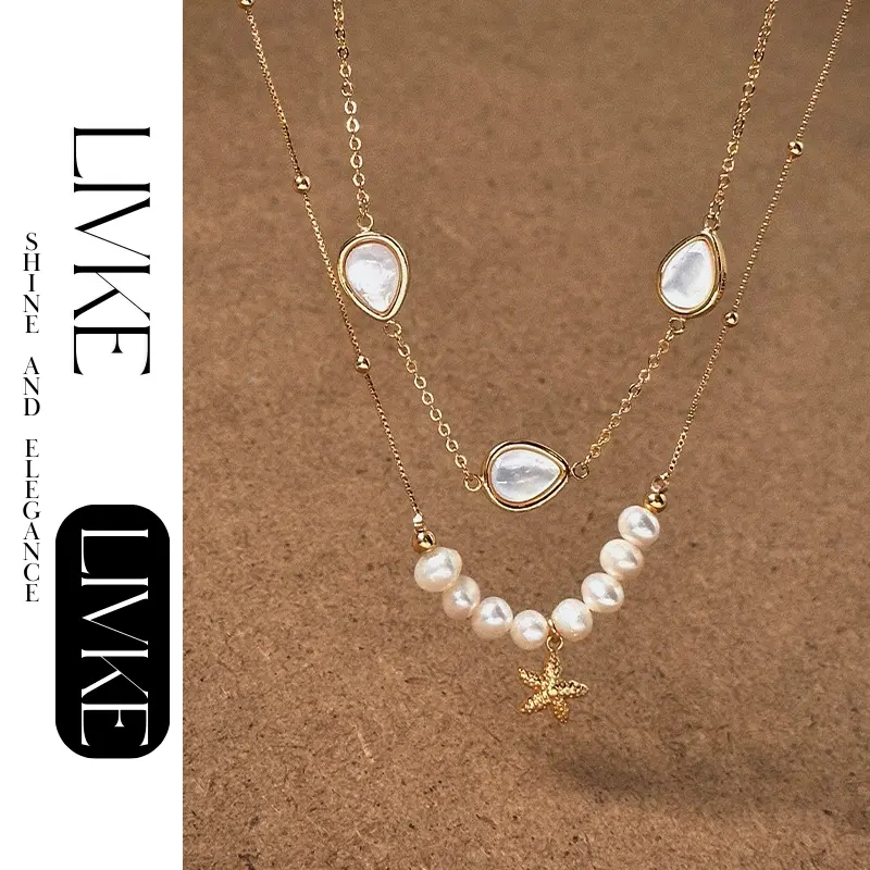 LIVKE’s layered pearl and shell necklaces styled with a white sundress and straw bag for beach-to-bar elegance.