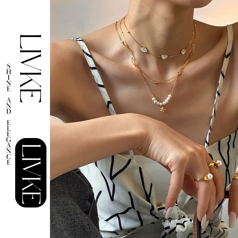 LIVKE’s layered pearl and shell necklaces styled with a white sundress and straw bag for beach-to-bar elegance.