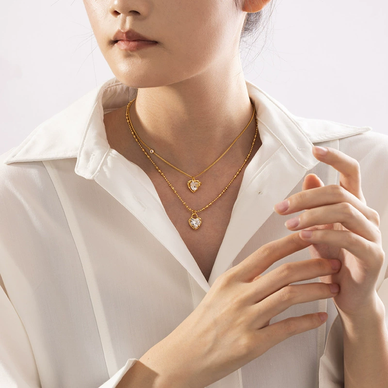 LIVKE’s gold vintage heart necklace with cubic zirconia, layered with a thin chain for minimalist office elegance.