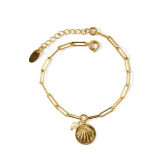 LIVKE’s gold shell and pearl bracelet styled on a wrist with a linen sleeve for coastal everyday elegance.