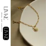 Vintage Shell & Pearl Bracelet 3 LIVKE’s gold shell and pearl bracelet styled on a wrist with a linen sleeve for coastal everyday elegance.