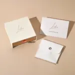 Jewelry Care Set 5 Beige drawer box open with polishing cloth, necklace and ring on velvet background