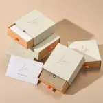 Jewelry Care Set 2 Beige drawer box open with polishing cloth, necklace and ring on velvet background