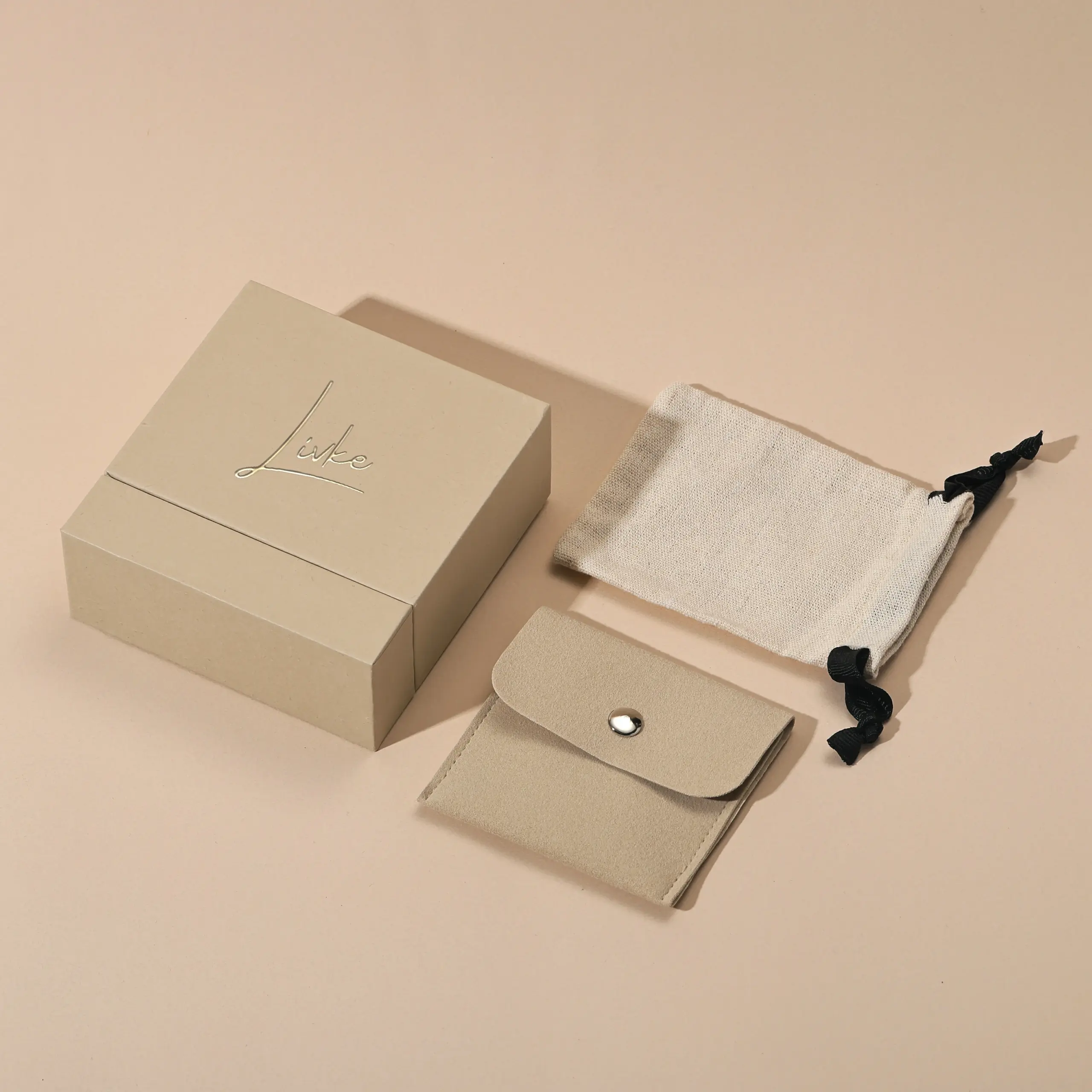 Beige drawer box open with polishing cloth, necklace and ring on velvet background