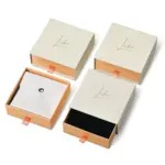 Jewelry Care Set 4 Beige drawer box open with polishing cloth, necklace and ring on velvet background