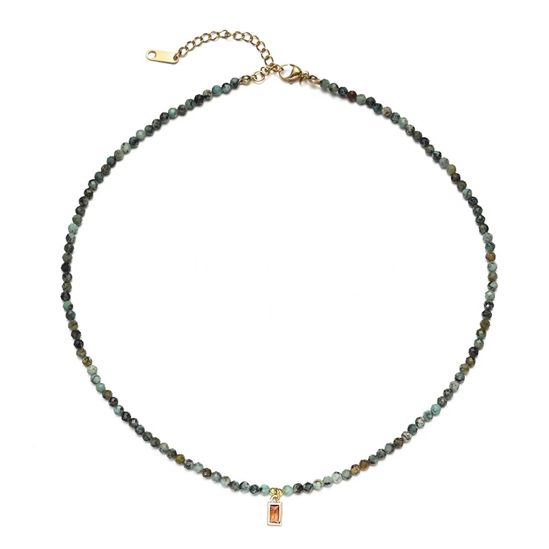 Adjustable LIVKE brass necklace with amethyst and turquoise beads layered over linen dress for bohemian everyday style.