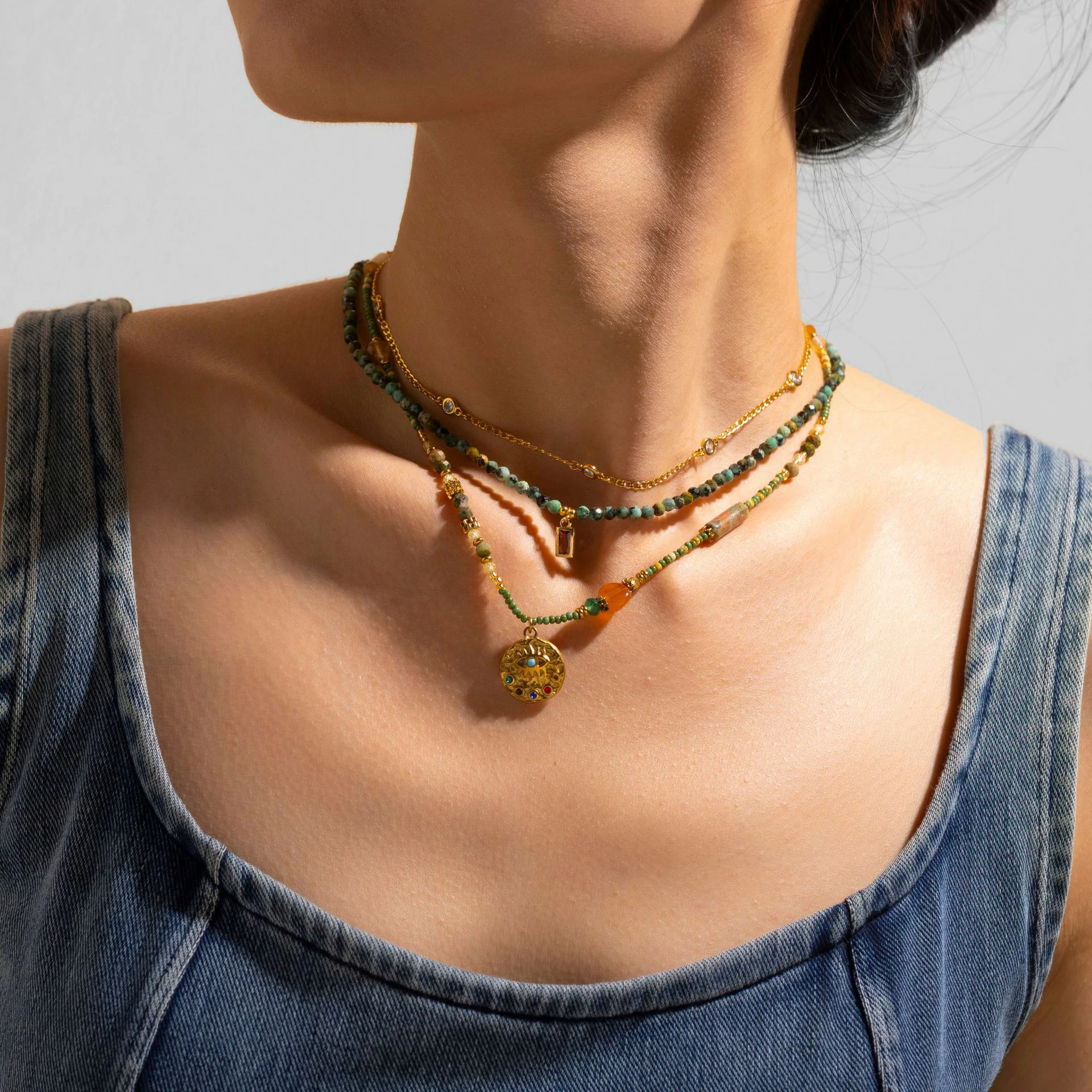 Adjustable LIVKE brass necklace with amethyst and turquoise beads layered over linen dress for bohemian everyday style.