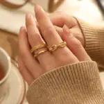 Braided Gold Rings – Geometric Hollow Design 2 Stacked LIVKE braided and chain rings on hand with bohemian embroidery sleeve, showcasing boho-chic layering.