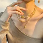 Woman wearing LIVKE cat and shell necklace walking with cat on sunset beach, symbolizing pet love and coastal aesthetic jewelry