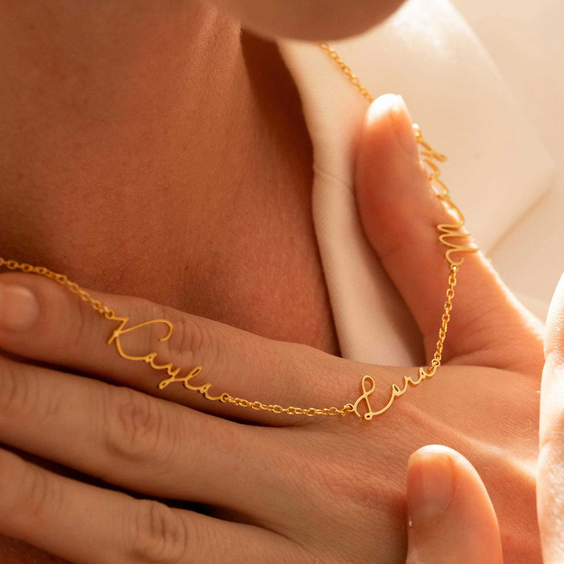 Gold name necklace with 'Believe' engraved in modern font on collarbone