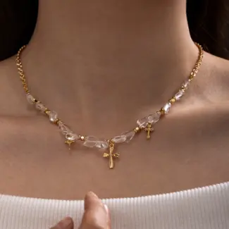 Young woman wearing LIVKE gold cross necklace with layered chains at music festival, blending spiritual jewelry with bohemian style