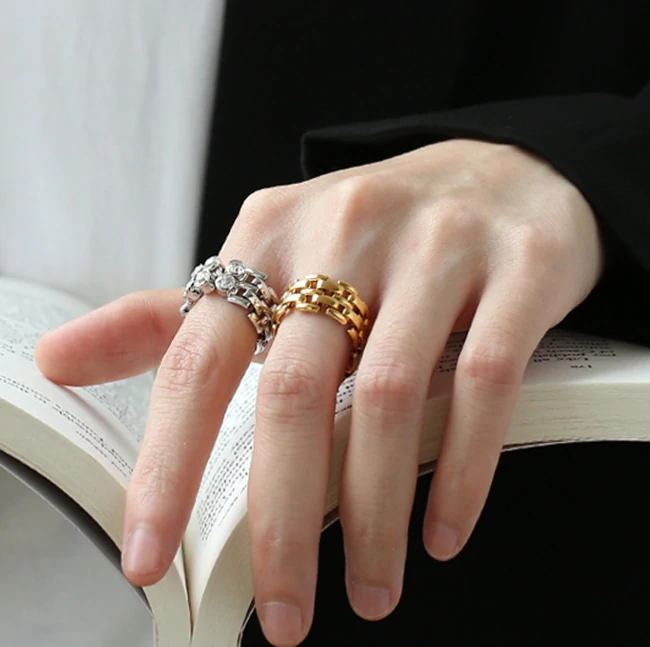 Hand wearing LIVKE gold zircon rings with geometric layout, paired with minimalist bands for urban chic style