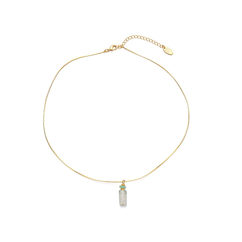 Woman wearing LIVKE green aventurine and white jade necklace with cashmere sweater, showcasing minimalist jewelry for urban elegance