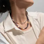 Lapis Lazuli & Gold Beaded Necklace 2 Woman wearing LIVKE lapis lazuli and gold beaded necklace with tailored black dress, showcasing mysterious yet elegant office-to-event jewelry