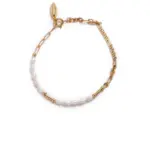 Gold-Plated Moonlight Pearl Bracelet 9 Stylist mixing LIVKE gold chain modules with baroque pearls on antique velvet tray in Paris concept store