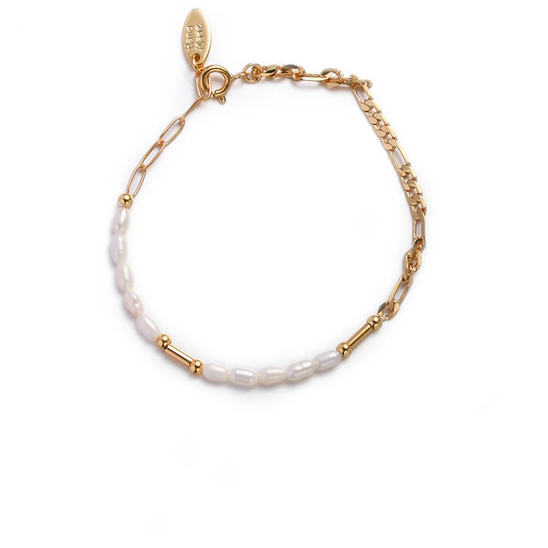 Stylist mixing LIVKE gold chain modules with baroque pearls on antique velvet tray in Paris concept store