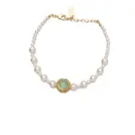 Gold-Plated Moonlight Pearl Bracelet 13 Stylist mixing LIVKE gold chain modules with baroque pearls on antique velvet tray in Paris concept store