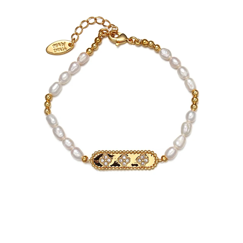 Stylist mixing LIVKE gold chain modules with baroque pearls on antique velvet tray in Paris concept store