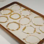 Gold-Plated Moonlight Pearl Bracelet 2 Stylist mixing LIVKE gold chain modules with baroque pearls on antique velvet tray in Paris concept store