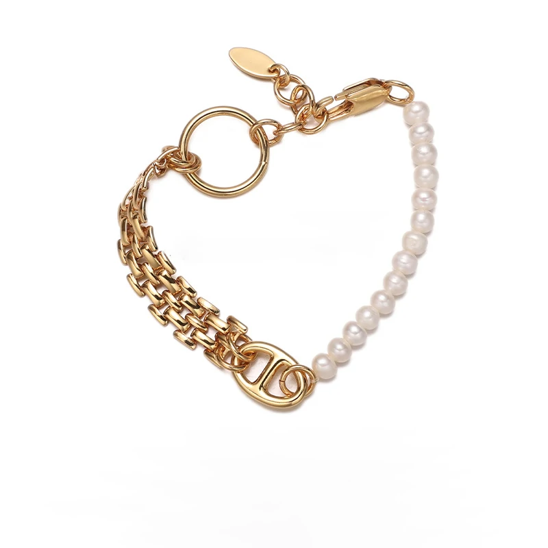 Stylist mixing LIVKE gold chain modules with baroque pearls on antique velvet tray in Paris concept store