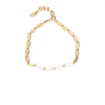 Gold-Plated Moonlight Pearl Bracelet 12 Stylist mixing LIVKE gold chain modules with baroque pearls on antique velvet tray in Paris concept store