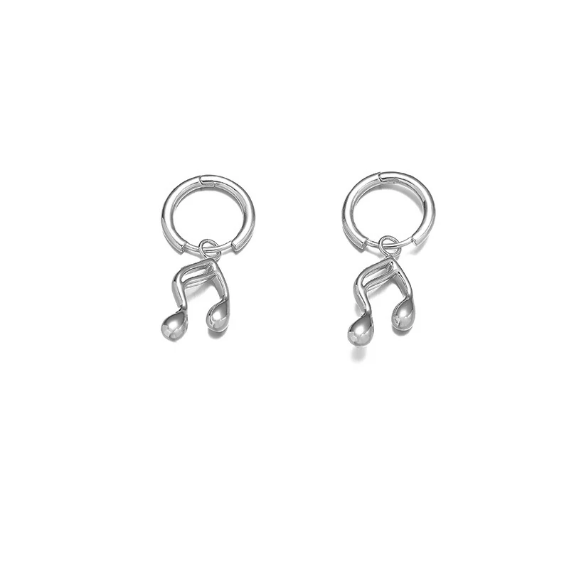 Gold note-shaped ear cuff on model's ear with sheet music background