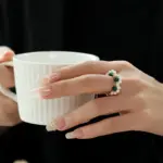 Adjustable Pearl & Natural Stone Wrap Ring 3 Hand wearing LIVKE adjustable wrap ring with pearls and green aventurine, layered with slim bands for boho chic style