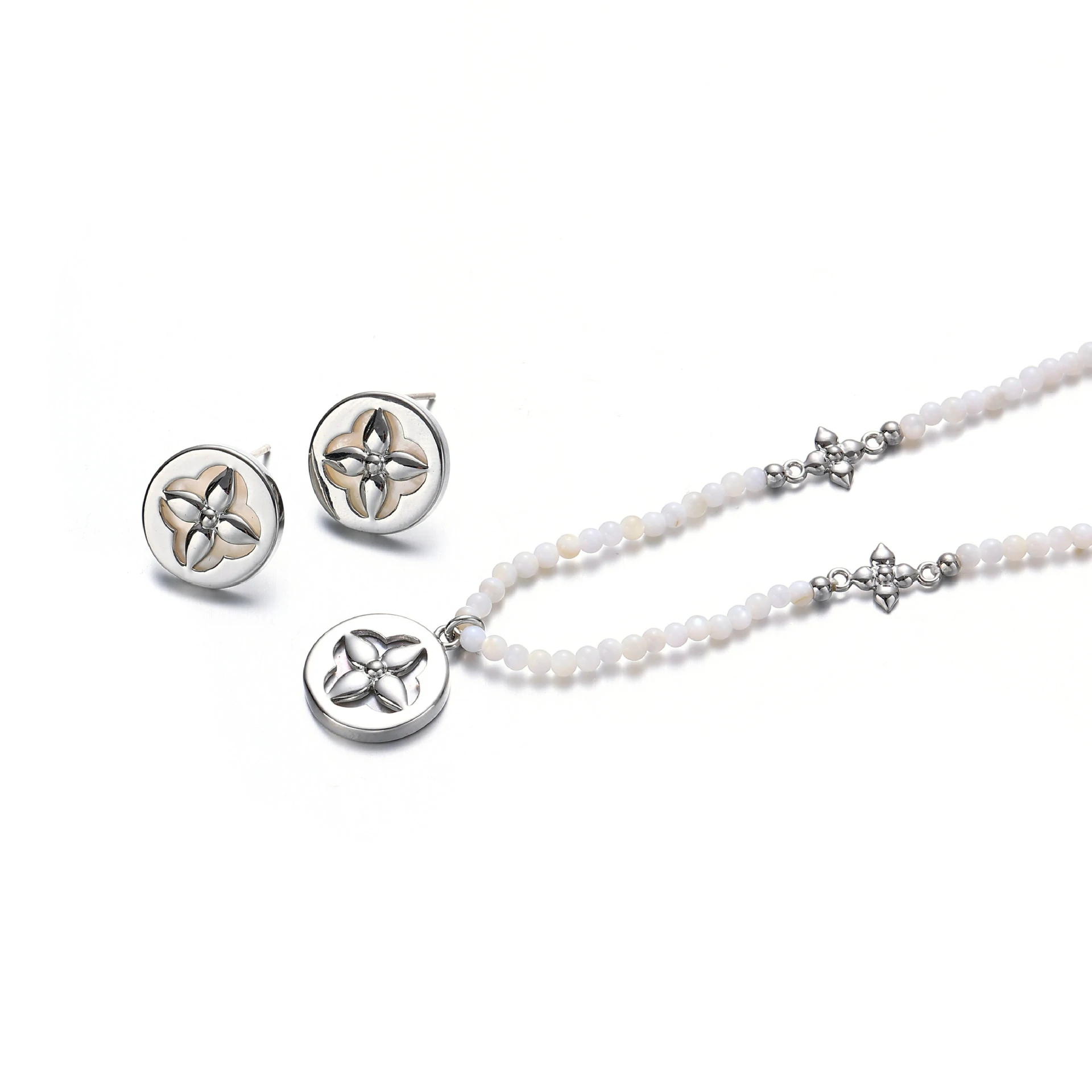 Woman wearing LIVKE shell bead necklace with floral pendant at beach sunset, showcasing boho chic jewelry for summer adventures