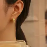 Spiral Threader Ear Cuffs 2 Contemporary art gallery visitor wearing LIVKE gold spiral ear cuffs with minimalist outfit, showcasing architectural jewelry styling