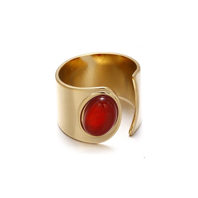 Hand wearing LIVKE red agate titanium ring with textured gold band in boardroom setting, showcasing power jewelry for professionals