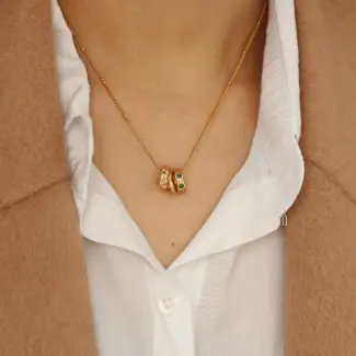 Model wearing LIVKE emerald CZ triple hoop necklace with black turtleneck