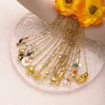 Coastal Minimalist Necklace 4 Natural tumbled shell pendant on 18K gold-plated chain styled with linen shirt and jeans at beachside café