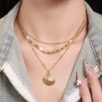 Coastal Minimalist Necklace 2 Natural tumbled shell pendant on 18K gold-plated chain styled with linen shirt and jeans at beachside café