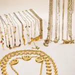 Coastal Minimalist Necklace 5 Natural tumbled shell pendant on 18K gold-plated chain styled with linen shirt and jeans at beachside café