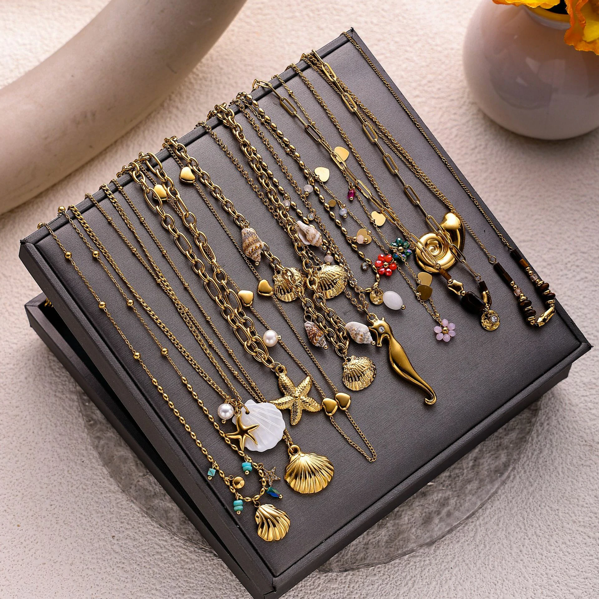 livke-tumbled-shell-necklace-california-beach (8) Natural tumbled shell pendant on 18K gold-plated chain styled with linen shirt and jeans at beachside café